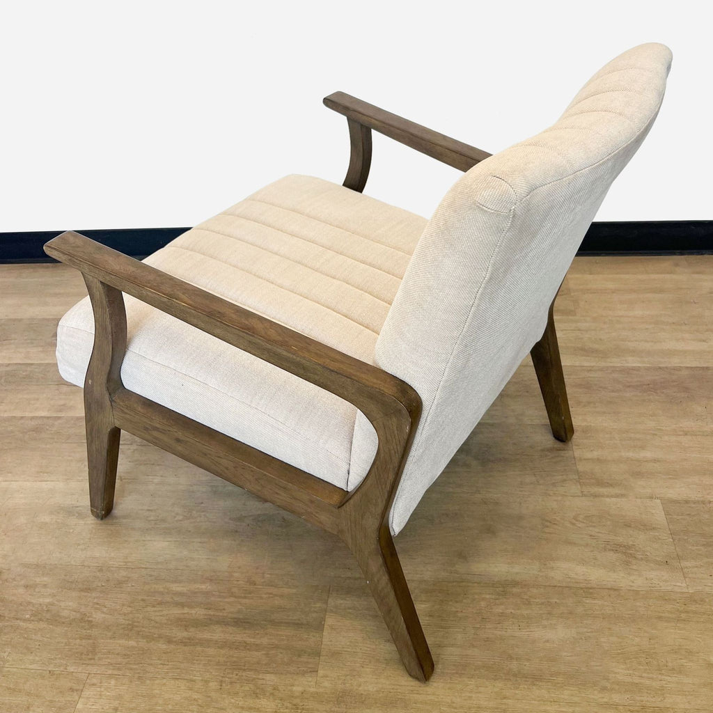 Rear-side angle of the Burton chair by Four Hands, highlighting the wooden frame and beige upholstery.