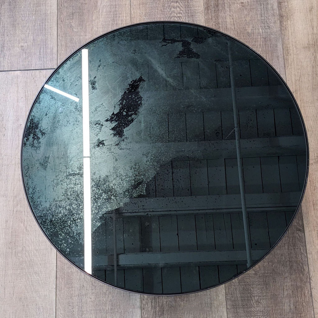 a round mirror with a black glass surface.