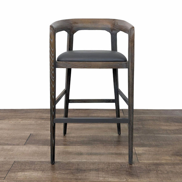a set of four bar stools with a black leather seat and back.