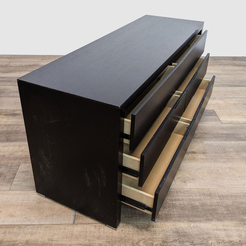 a black lacquer chest of drawers with a metal base.