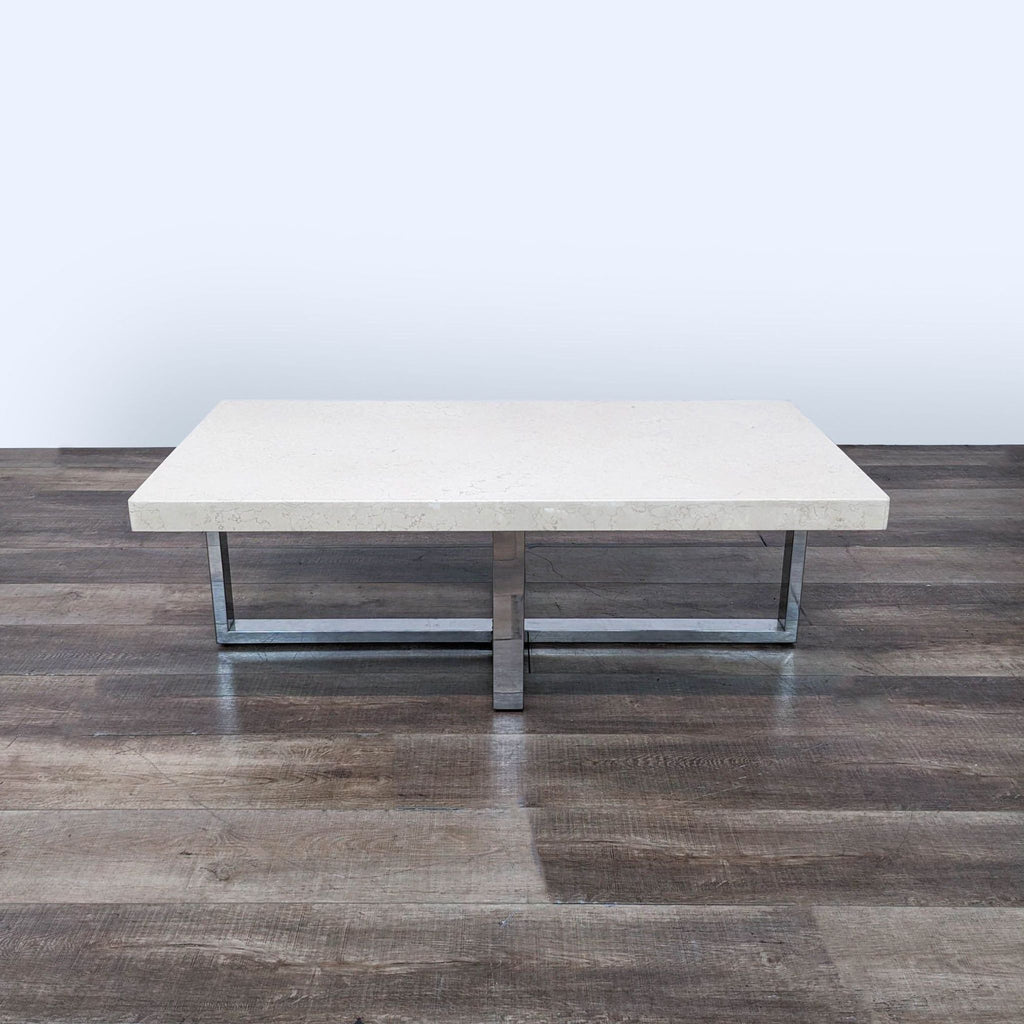 a coffee table with a stainless steel base and a polished stainless steel base.