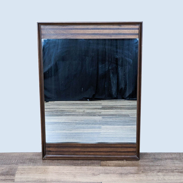 a vintage mirror with a black and white glass.