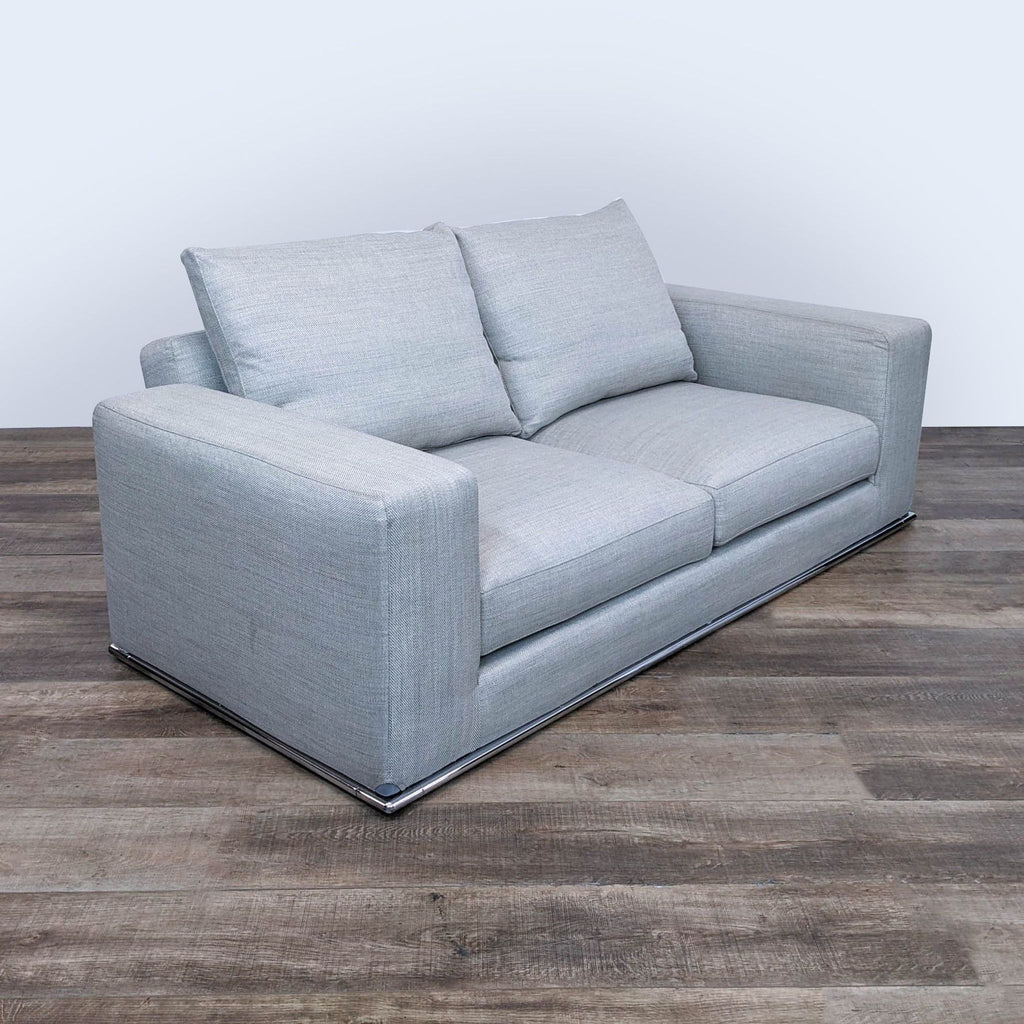 sofa with a modern design. the sofa is made of a soft grey fabric with a modern design