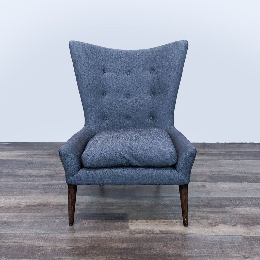 a pair of blue velvet wingback chairs