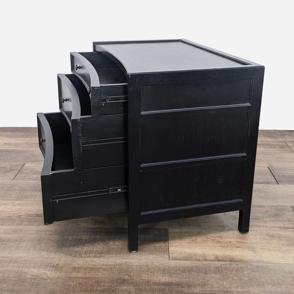 a black lacquer desk with three drawers.