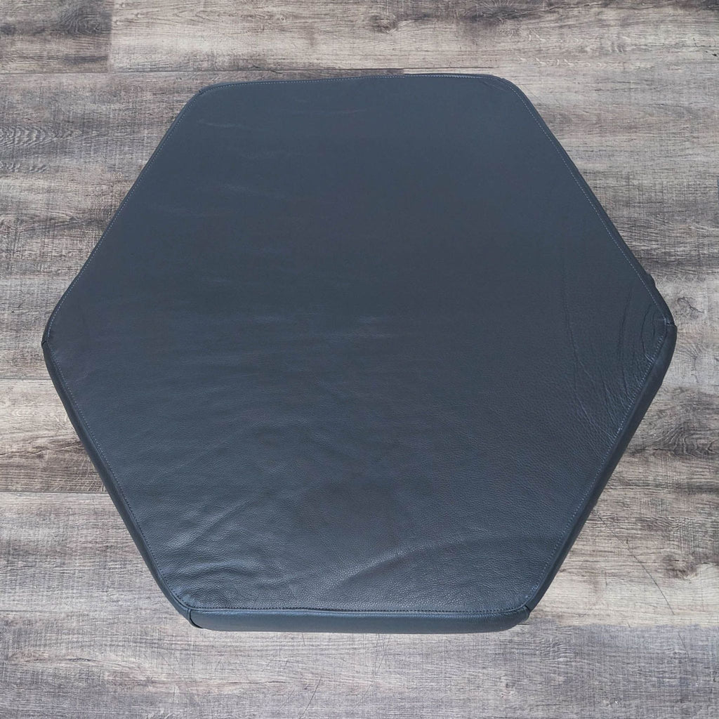 a black foam gym mat with a hexagon shape.