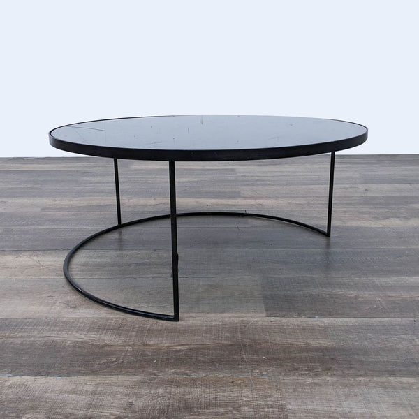 Minimalist round coffee table by Notre Monde with aged mirror top and metal base.