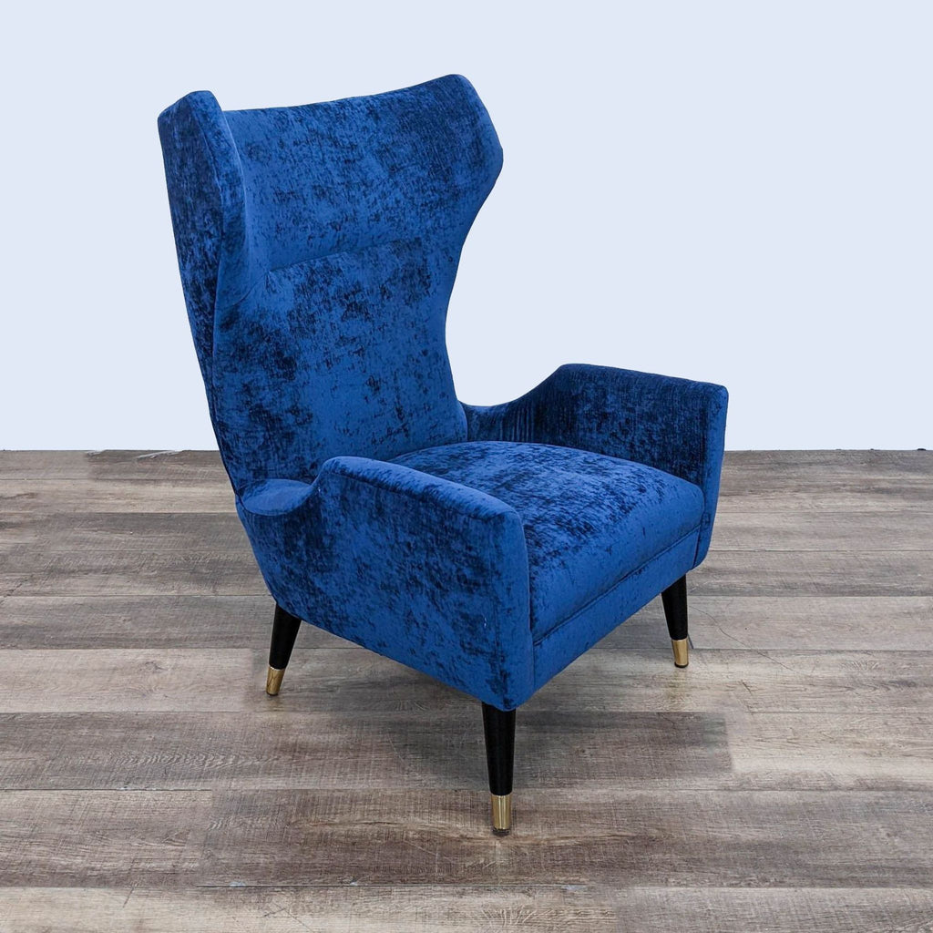 a pair of blue velvet wingback chairs