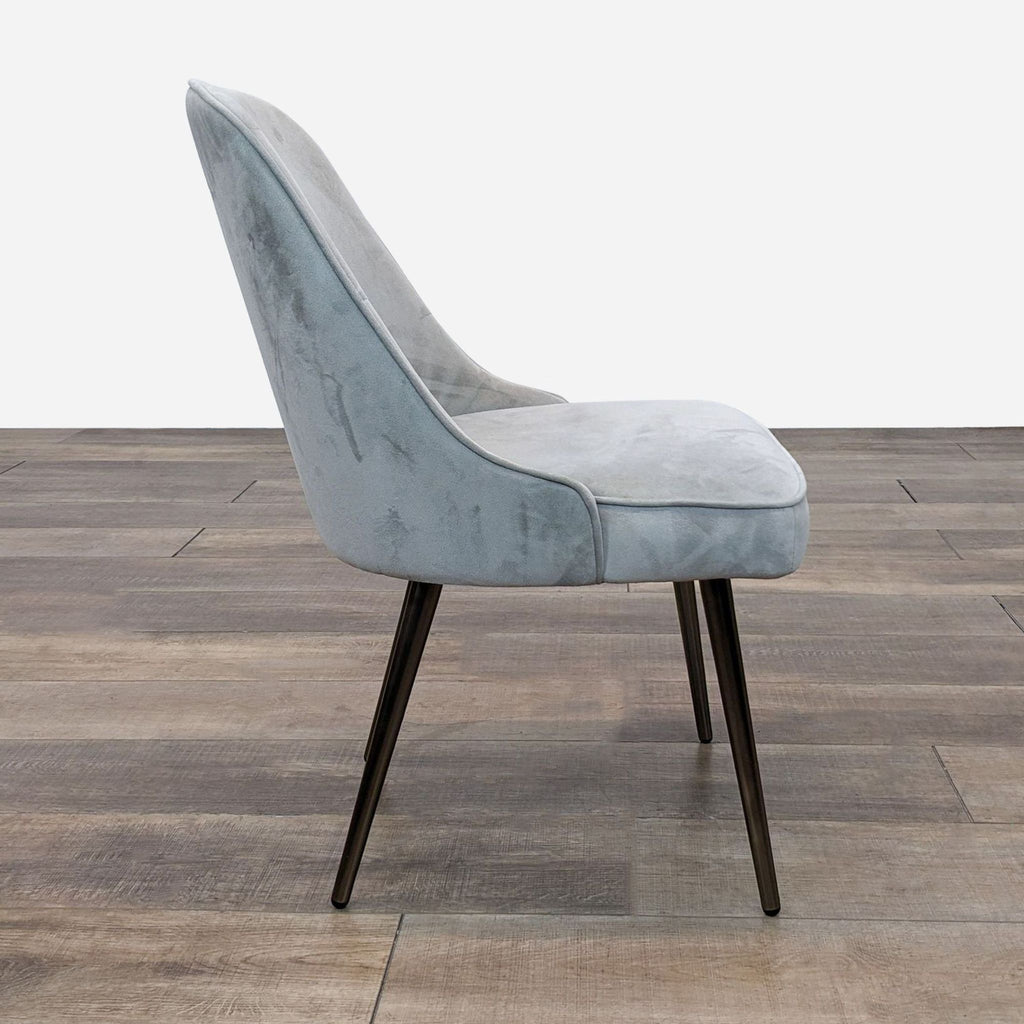 Side view of mid-century style dining chair by West Elm with soft upholstery.