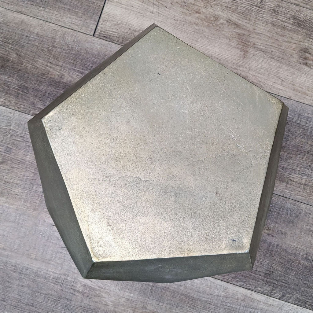 a metal hexagon shaped table top with a metal finish.