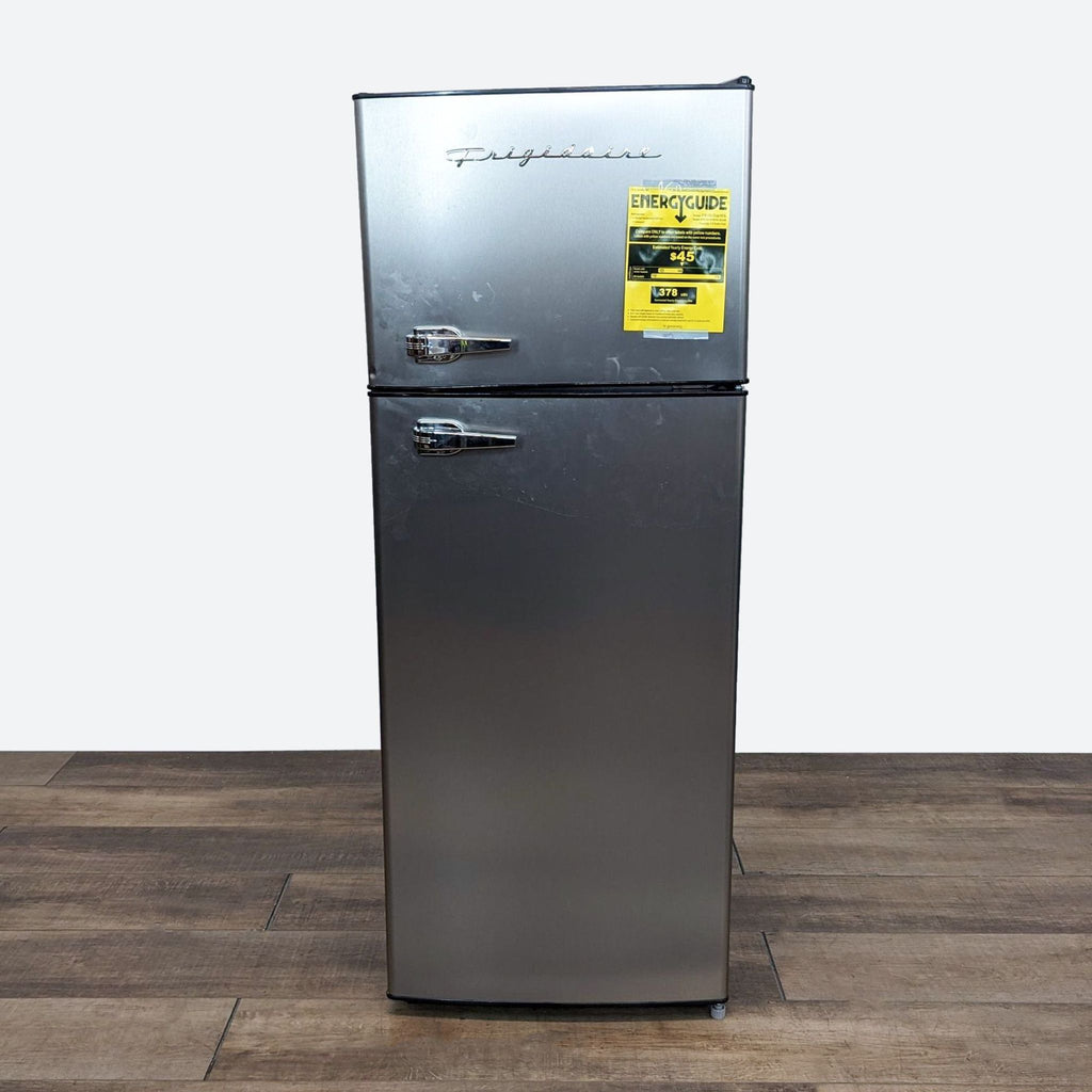 a small refrigerator sitting on top of a wooden floor.