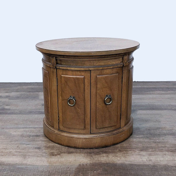 a round coffee table with two drawers and a round top.