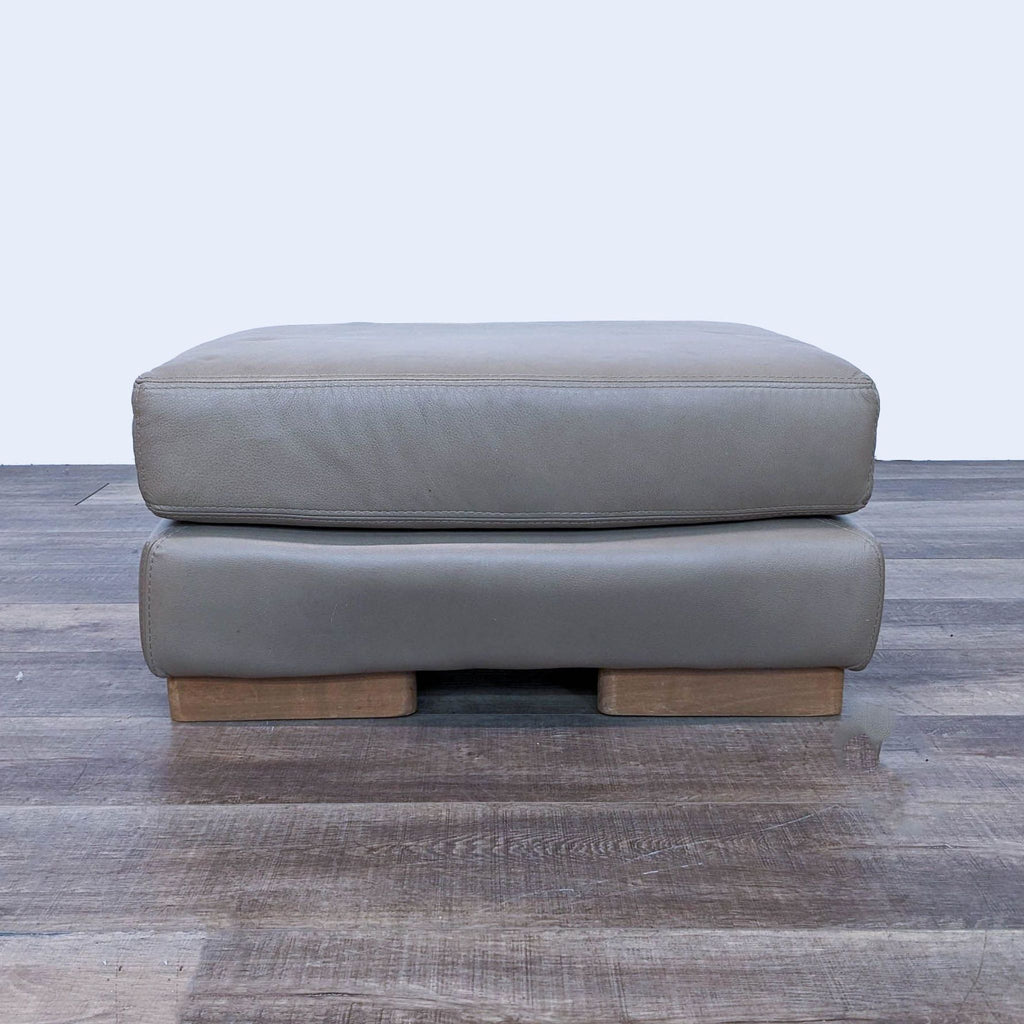 a pair of grey leather ottomans