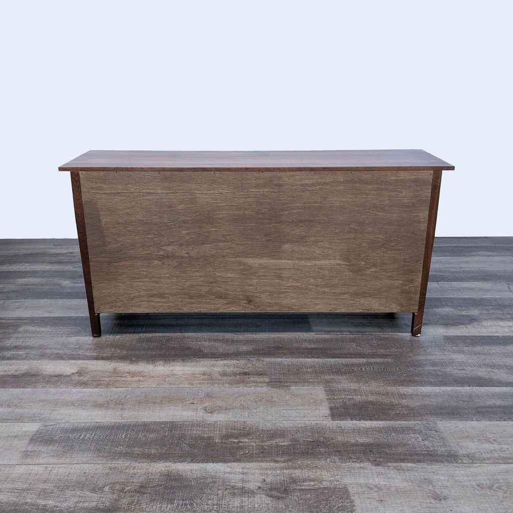 Back view of Stickley dresser in rich wooden finish on a wooden floor.