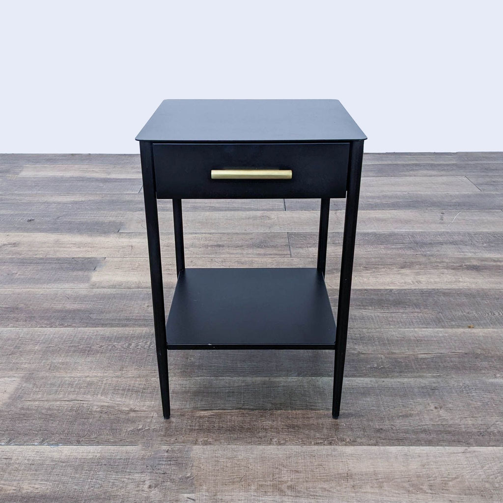 the side table is a simple black finish with a brass drawer.