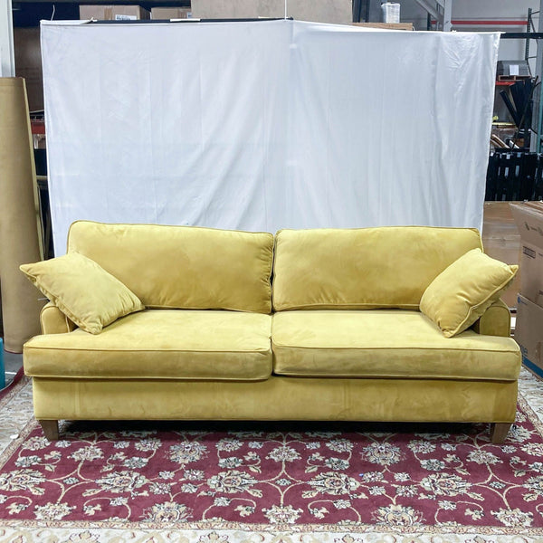 a vintage yellow velvet sofa with a matching pillow and matching pillow.