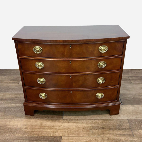 a mahogany chest of drawers with brass handles.