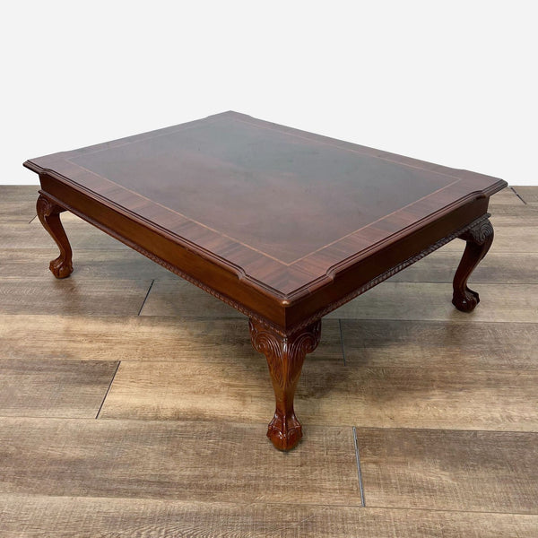 a mahogany coffee table with a carved top.
