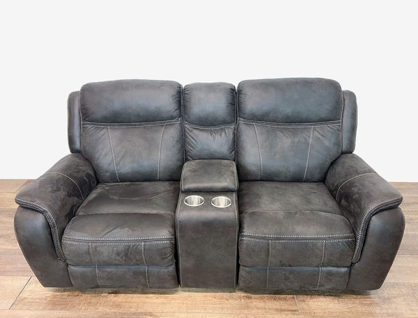 a black leather reclining sofa with a square foot rest.