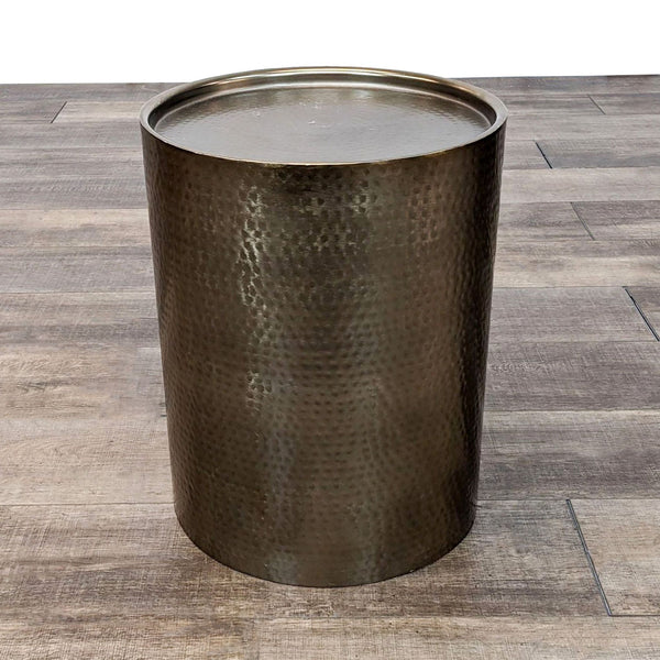 a large metal trash can with a round base.