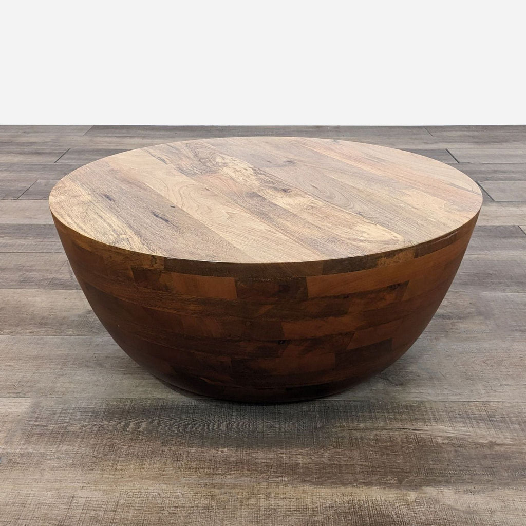 a large, round, wooden coffee table with a dark brown top.