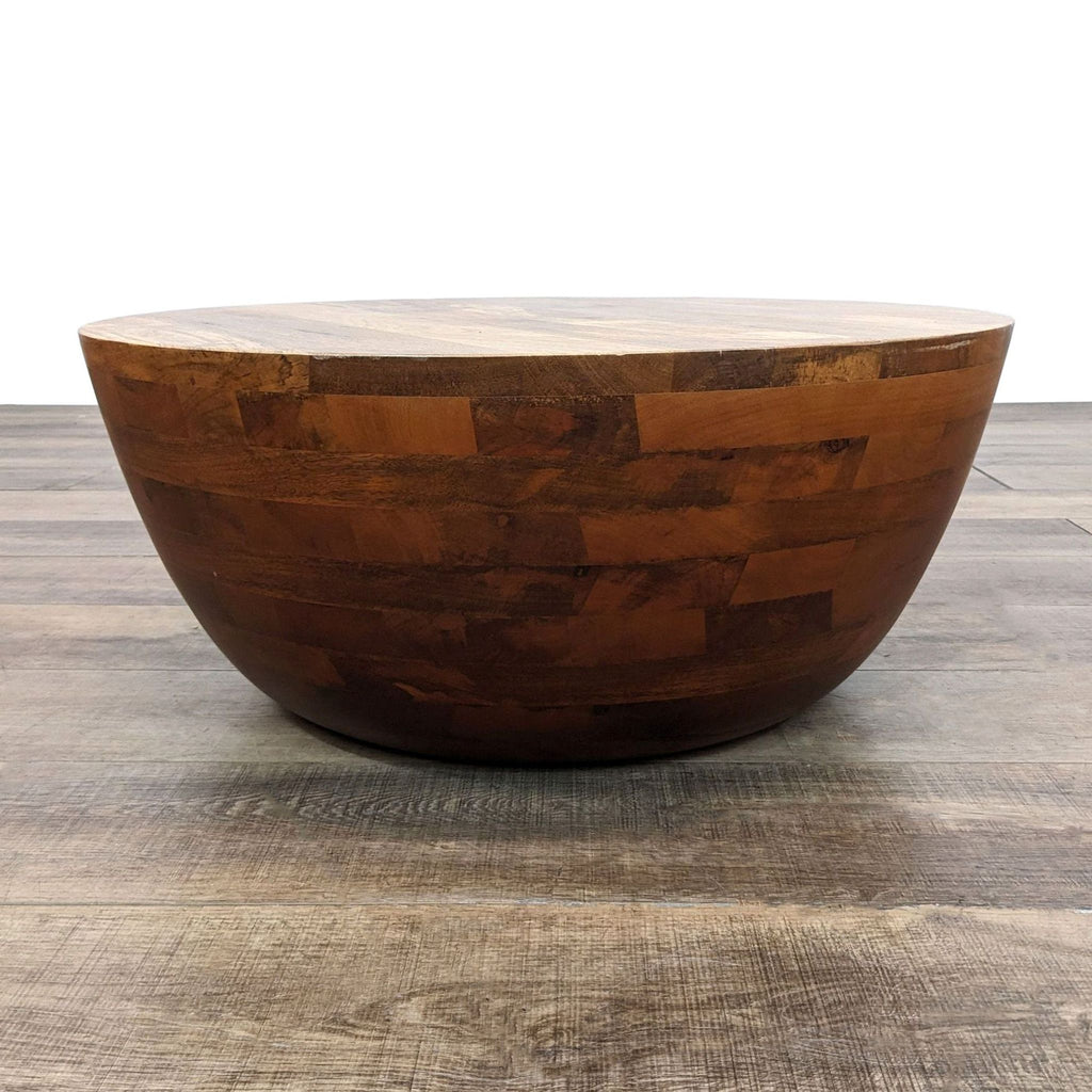 a large, round, wooden bowl with a natural finish.