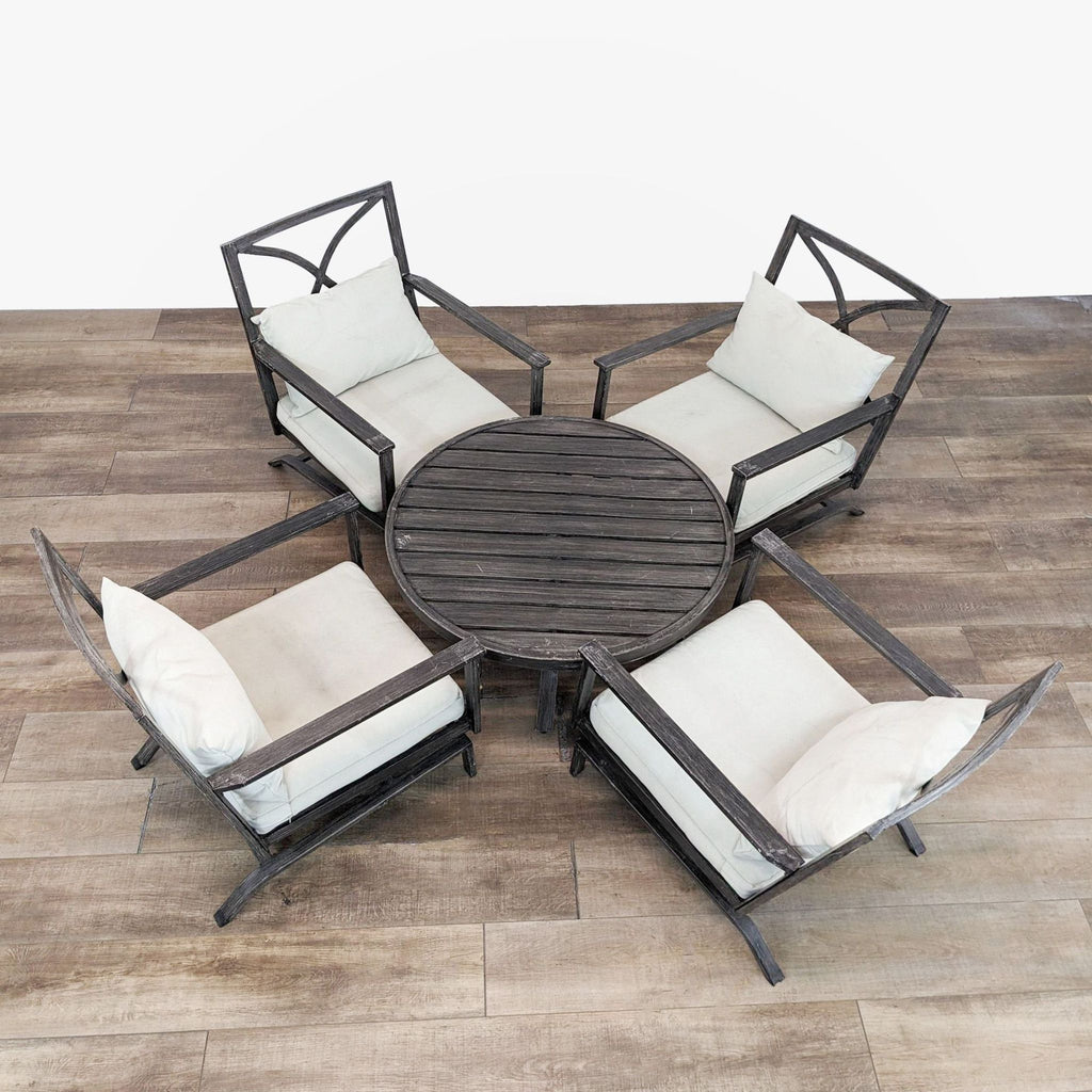 Top view of metal chairs with cushions surrounding a round metal coffee table.