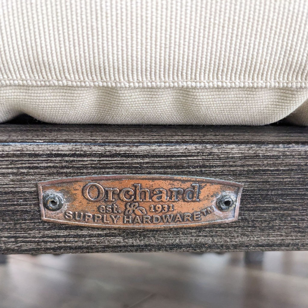 Close-up of Orchard branding on metal furniture from an outdoor set.