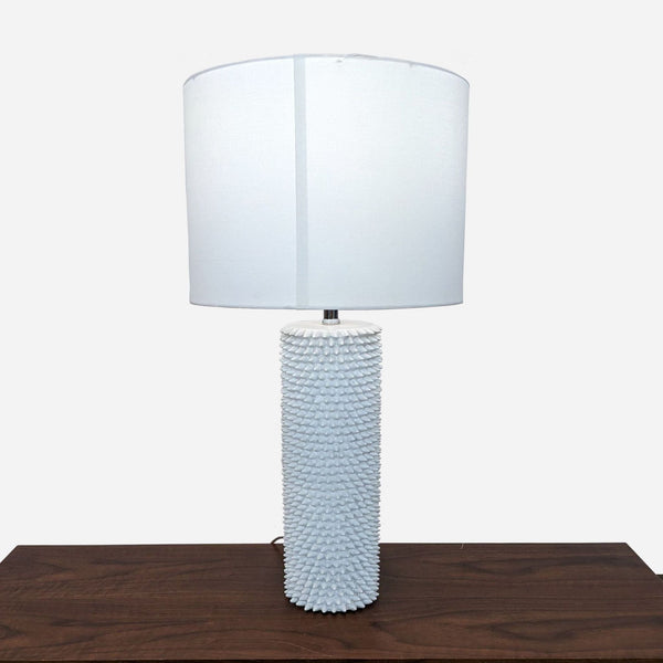 a table lamp with a white cylinder shade