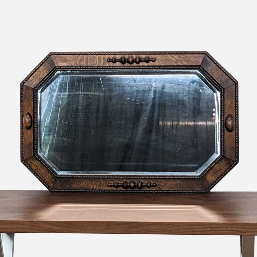 a large antique mirror with a dark wood frame.