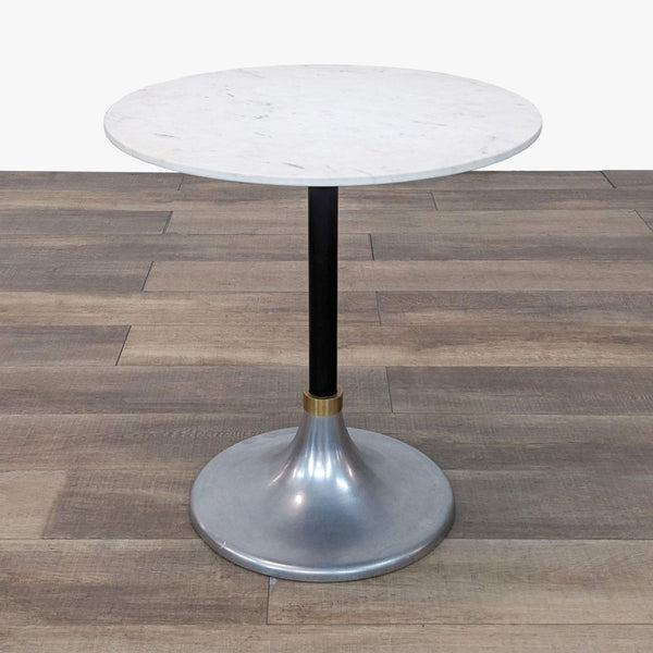 a round marble table with a brass base and a black base.