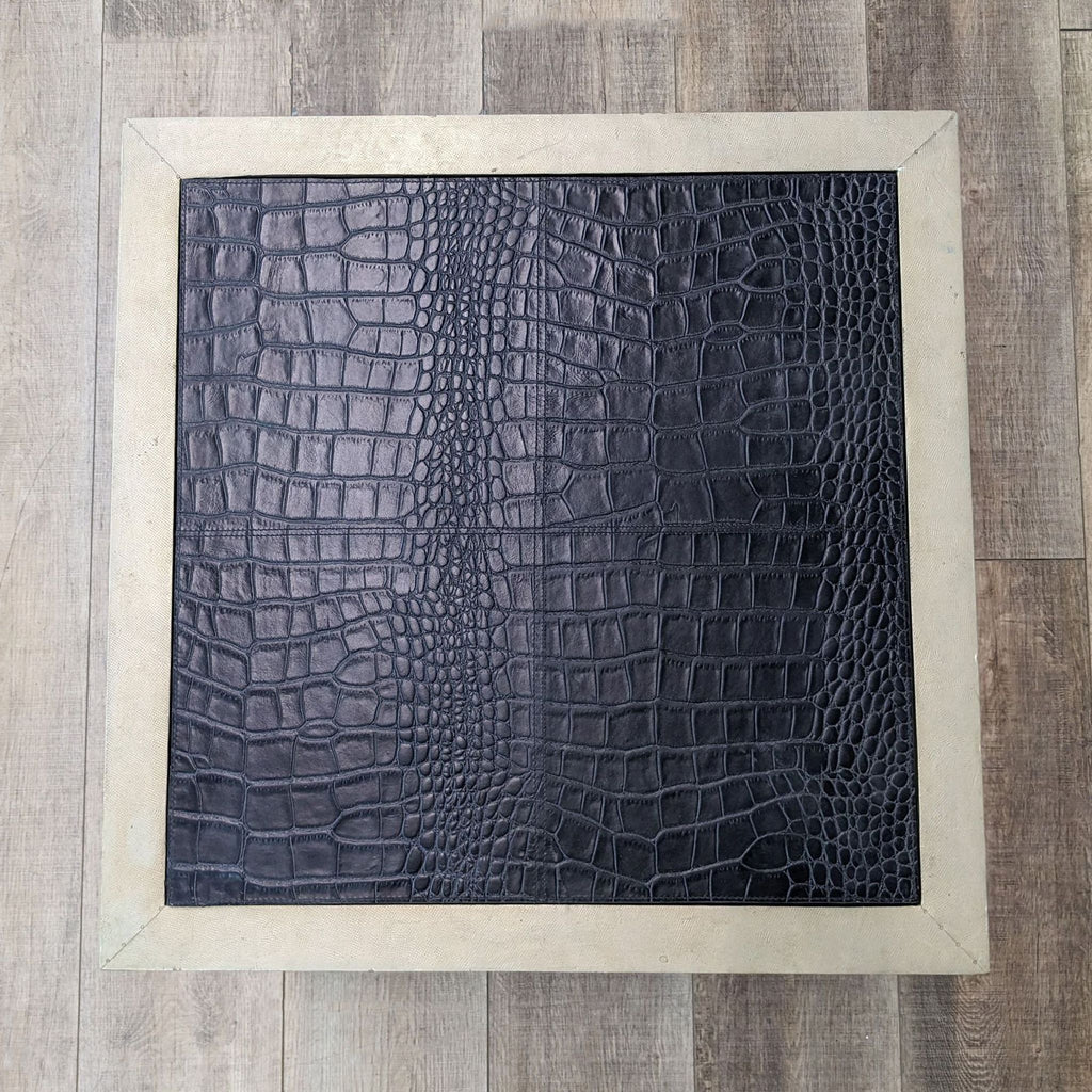 a black alligator skin rug with a white frame.