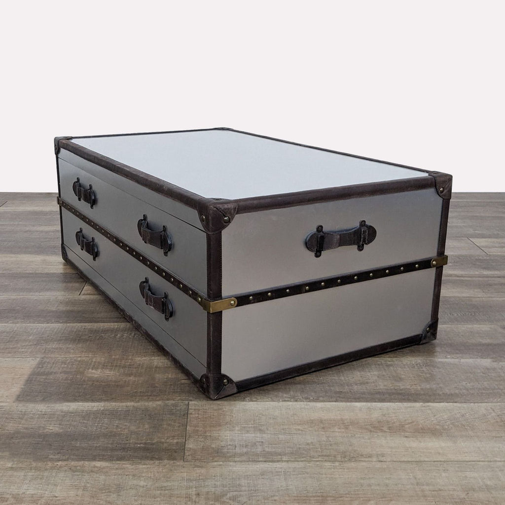 a black and white metal trunk with a metal handle.