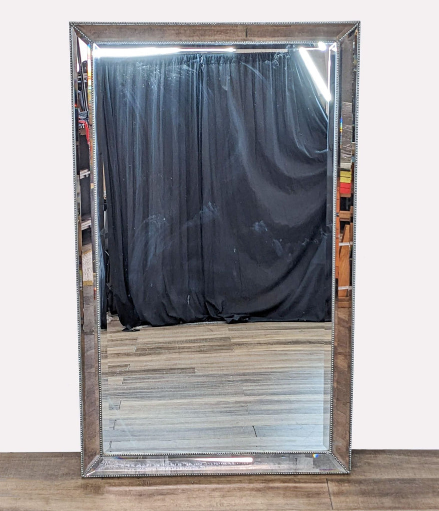 a large vintage italian silver and wood mirror with a black curtain.