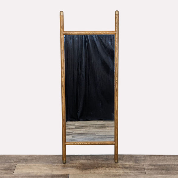 a large mirror with a black fabric hanging on a wooden frame.