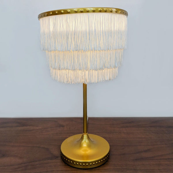 a vintage brass table lamp with fringed fringes.