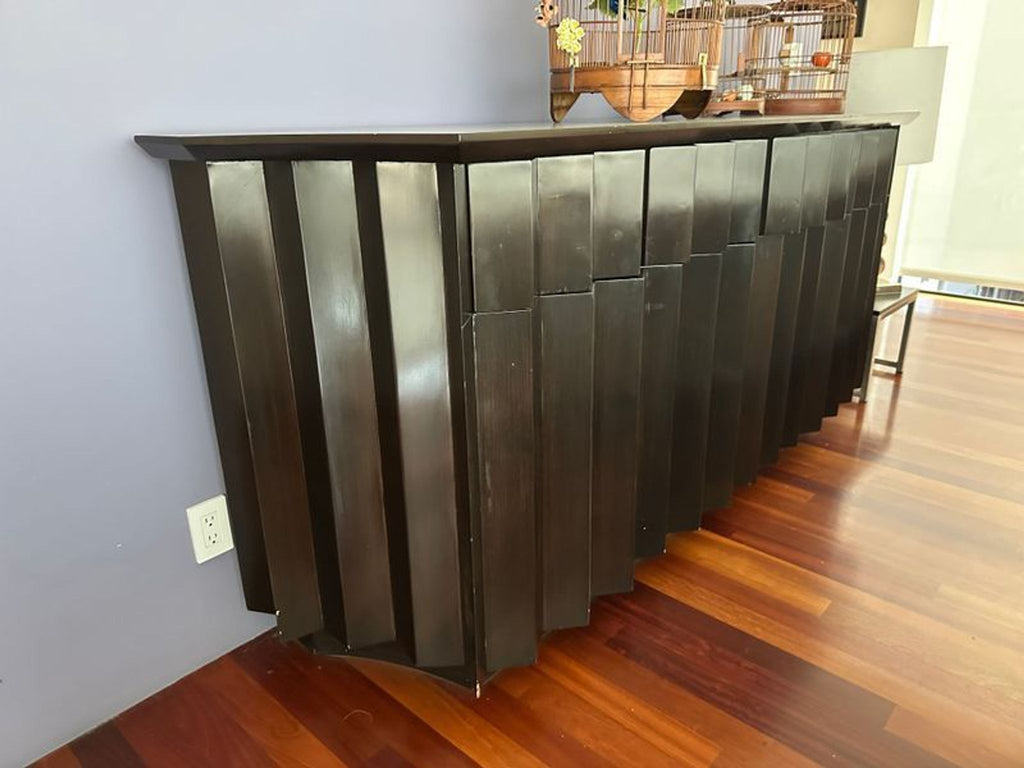 1. Modern black sideboard with geometric panels, placed against a wall on wooden flooring by Derepage Design.  