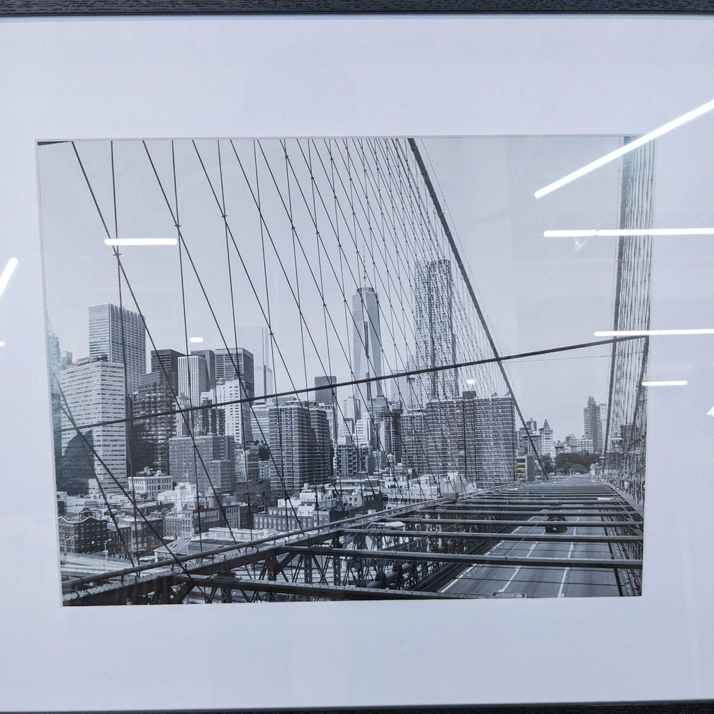 a black and white photo of a bridge with buildings in the background.