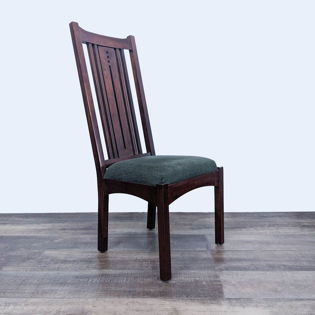 a wooden chair with a green cushion