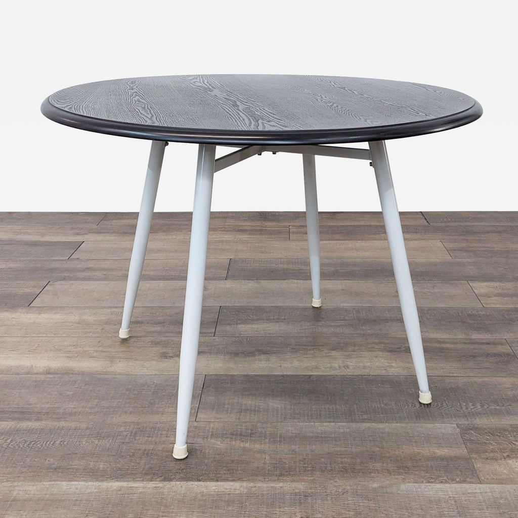 a round table with a black marble top and white legs.