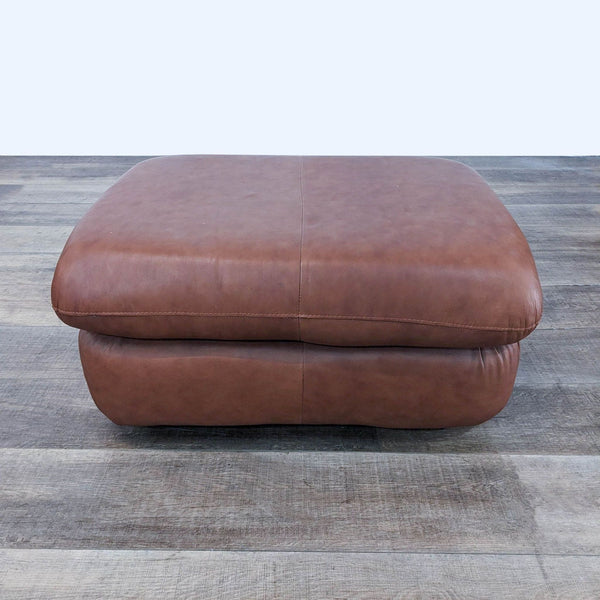 a pair of leather ottomans with a square base