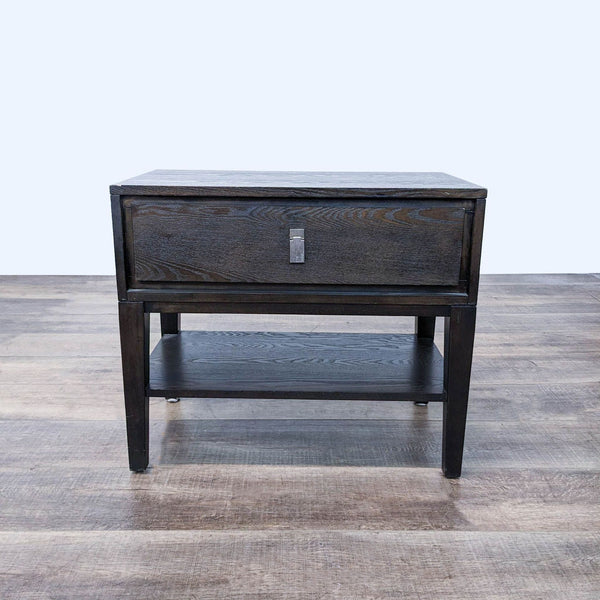 a dark wood bedside table with a drawer.