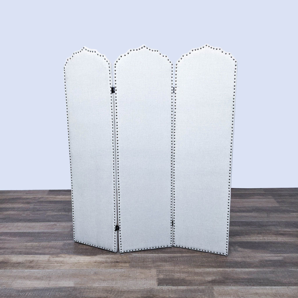 a large white folding mirror with a black studded back.