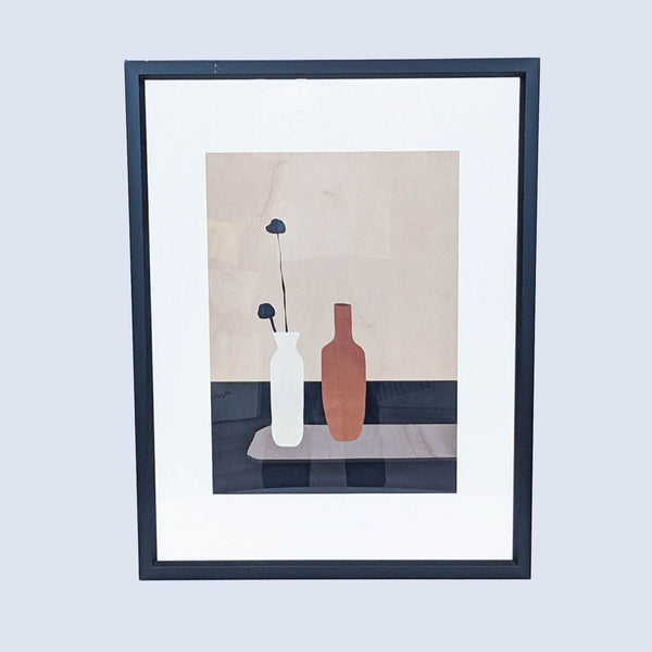 a framed print of a vase and a bottle
