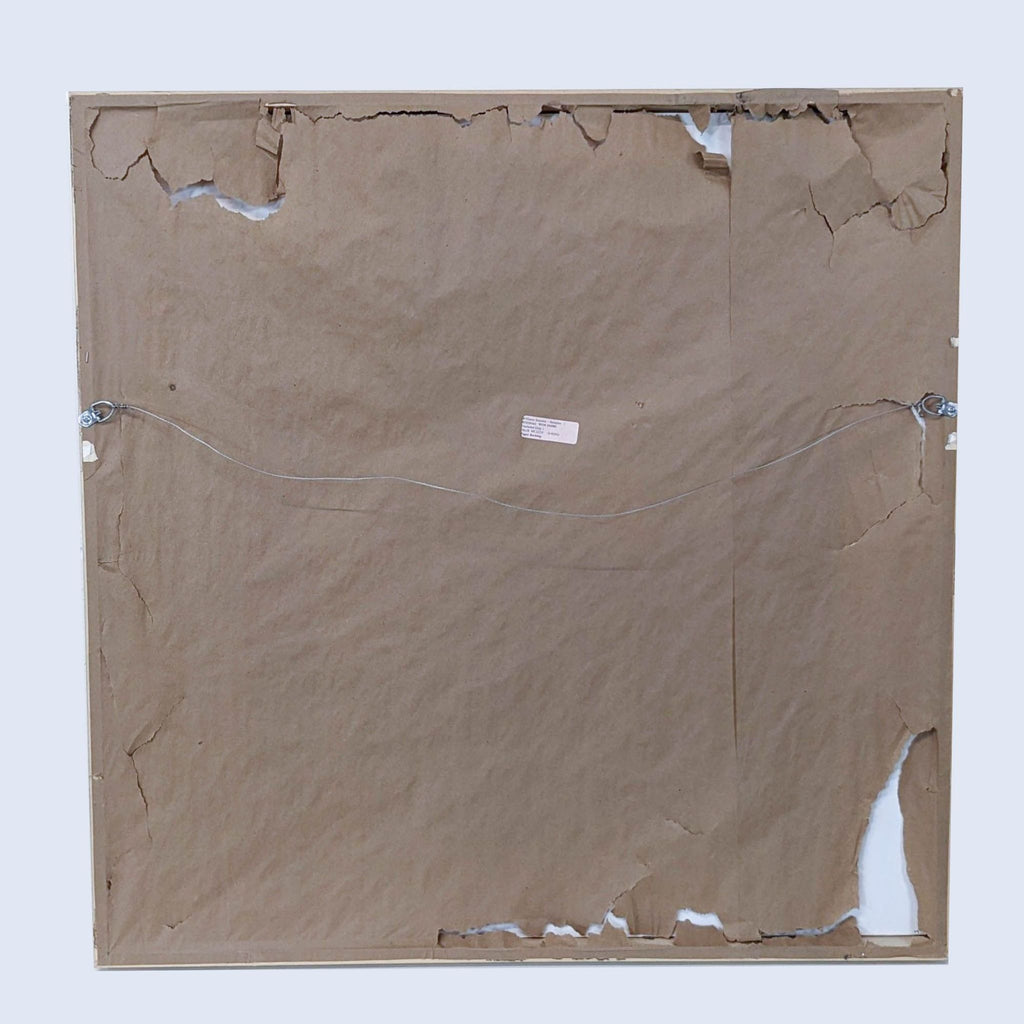 a square cardboard frame with torn edges and a label on the front.