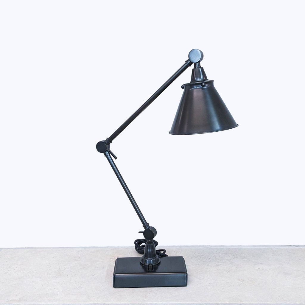 a black metal desk lamp with a black metal shade.