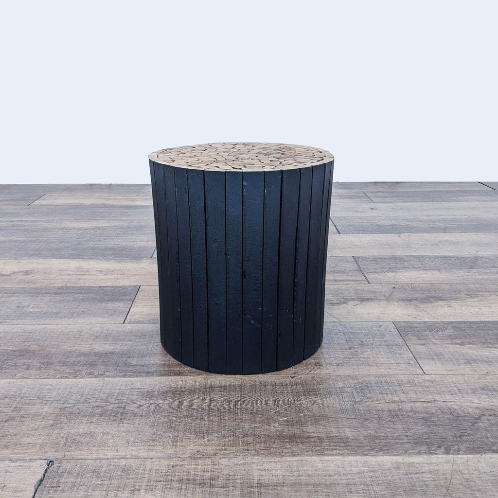 a black wooden stool with a wooden base.