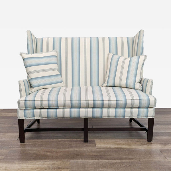 a blue and white striped sofa with a striped back and two pillows