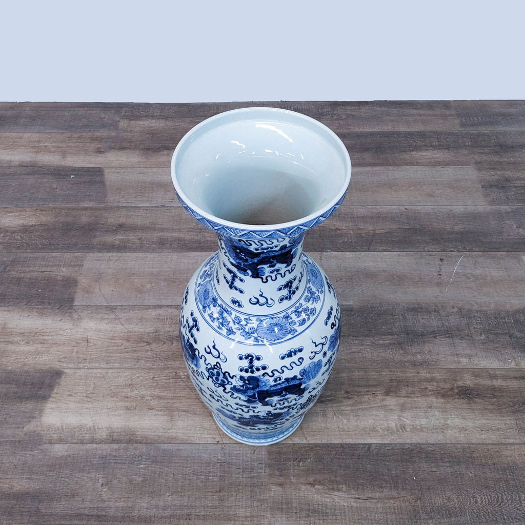 a blue and white vase on a wooden table.