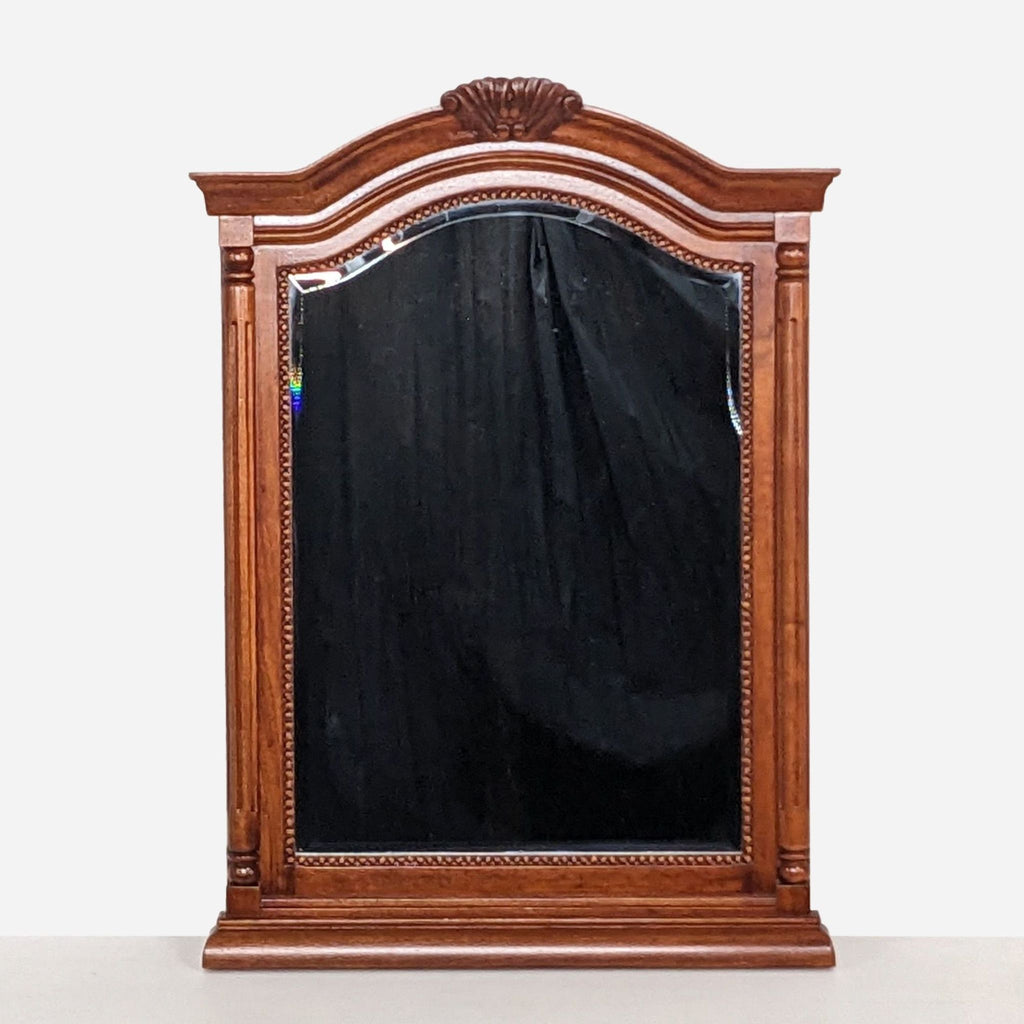 a large antique mahogany mirror with a carved frame and a black background.